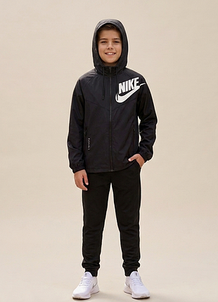 Дитяча вітровка nike sportswear windrunner, виготовлена в чорному кольорі з білим логотипом.