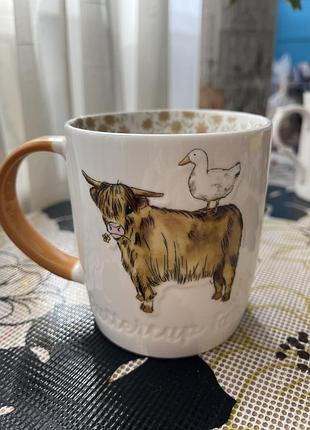 Керамічний кухоль-бочка cooksmart із серії "buttercup farm", на якому зображена шотландська високогірна корова з качкою на спині.