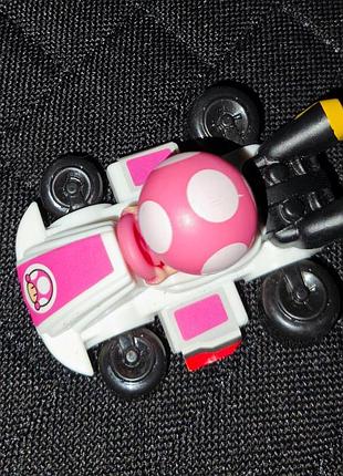 Игрушка тоадетта (toadette) на белом карте из серии mario kart. выпускавшаяся компаниями jakks pacific или в рамках серии игрушек mcdonald’s