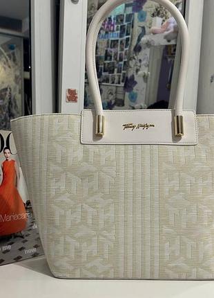 Стильна сумка-шопер tommy hilfiger у світлому відтінку з фірмовим монограмним візерунком. елегантний дизайн доповнений золотистою фурнітурою та зручни