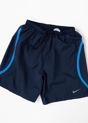 Чоловічі, спортивні шорти nike у темно-синьому кольорі з блакитними вставками. легка та зручна модель для бігу, тренувань і активног
