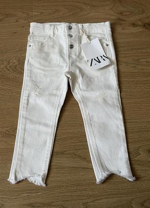 Дитячі білі джинси zara з рваними деталями та необробленим краєм.
