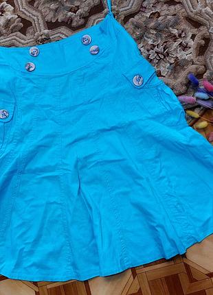 Спідниця трапецієподібного силуету з декором у вигляді ґудзиків та кишень. красивого блакитно кольору