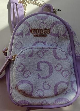 Модель guess evan mini crossbody backpack в расцветке "lilac mult". это компактный рюкзак-трансформер, который можно носить как кроссбоди.