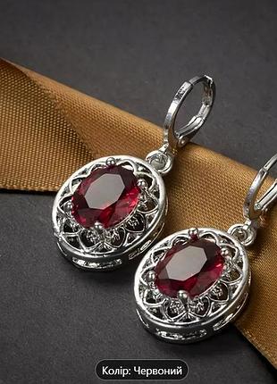 Сережки сріблястого кольору з червоними камінцями