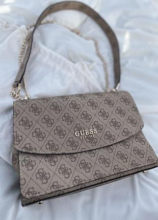 Жіноча сумка guess calista с характерним монограмним узором та цепочкой.