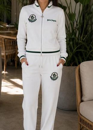 Женский белый спортивный костюм moncler выполнен из хлопка и украшен зелёным логотипом.