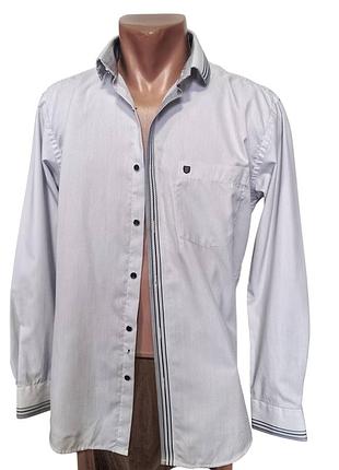 Белая мужская рубашка приталенного кроя slim fit имеет характерный мелкий узор и оригинальные контрастные элементы на воротнике и манжетах
