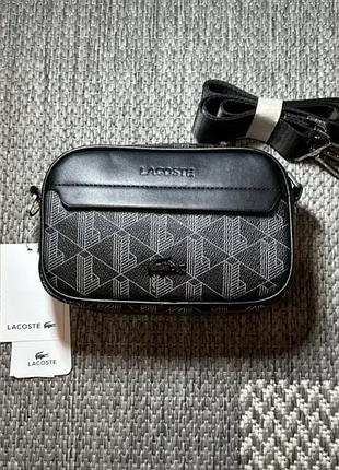 Сумка lacoste — компактна модель із монограмним принтом. міцний матеріал тримає форму, вміщує телефон і гаманець. нова, з ременем і бірками.