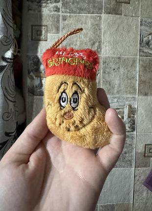 Плюшева підвіска у формі різдвяного носка від mcdonald's зображує грінча з написом "merry grinchmas