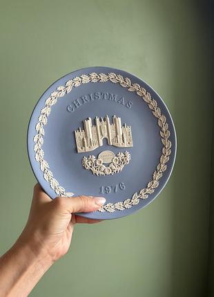Ця вінтажна декоративна тарілка wedgwood виготовлена з блакитного фарфору jasperware з білими рельєфними деталями.
