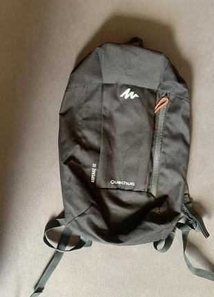 Рюкзак quechua arpenaz 10l чорного кольору з помаранчевим язичком блискавки.