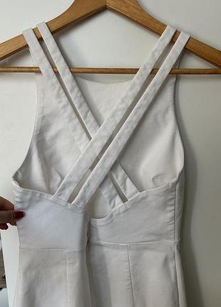 Белая мини-платье zara имеет характерный дизайн с перекрестными бретелями на спине.