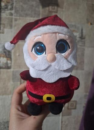 Плюшева іграшка санта клауса від кeel toys  має великі блискучі сині очі та червоний костюм