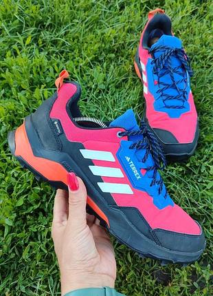Трекінгові черевики adidas terrex ax4 gore-tex у яскравому червоному кольорі з фіолетовими та білими акцентами.