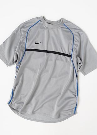Оригінальна, спортивна футболка nike dri-fit у світло-сірому кольорі з контрастними, синіми та чорними вставками. модель виконана у характерному стилі