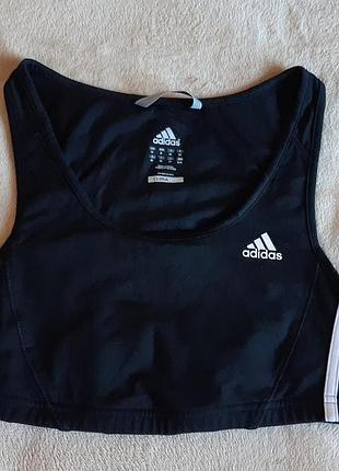 Чорний спортивний топ adidas з білими трьома смужками з боків виконаний із тканини climalite для відведення вологи.