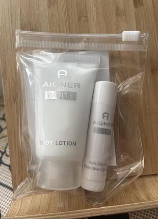 Дорожній косметичний комплект aigner white містить лосьйон для тіла aigner white та захисний бальзам для губ.
