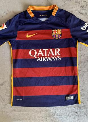 Дитяча футболка nike fc barcelona сезону 2015-16, яка вирізняється горизонтальними червоно-синіми смугами.