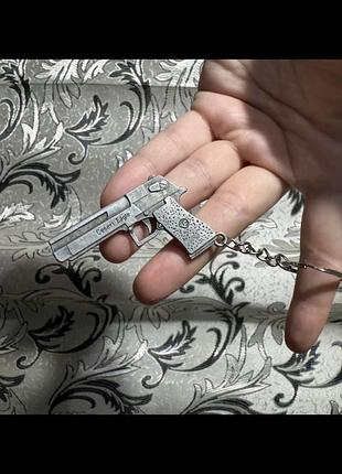 Металевий брелок у формі пістолета desert eagle, який зазвичай виготовляється із твердого сплаву.