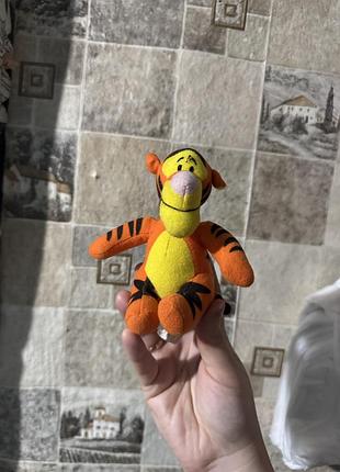 Плюшева іграшка тигра (tigger) за мотивами мультфільмів disney про вінні пуха має яскраві помаранчеві та чорні смуги.