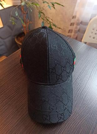 Чорна бейсболка gucci з монограмою gg та зелено-червоною смугою є класичною моделлю бренду.