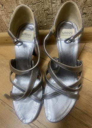 Босоножки выполнены из серебристой кожи и украшены логотипом armani collezioni.
