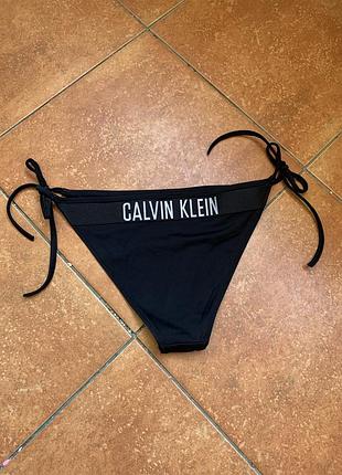 Чорні плавки від купальника calvin klein із зав'язками з боків та фірмовим логотипом на поясі