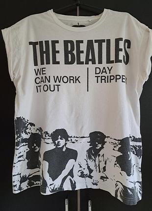 Белая футболка с черным принтом, посвященная группе the beatles.