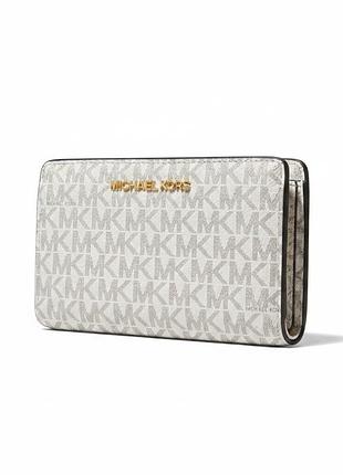 Женский кошелек michael kors jet set travel из фирменного канваса с принтом-монограммой mk белого цвета и золотистой фурнитурой.