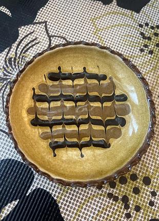 Вінтажна керамічна тарілочка виконана в техніці сліпвер (slipware) з характерним жовтим фоном і коричнево-чорним візерунком.