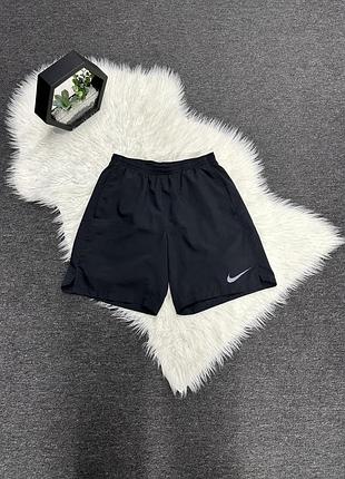 Чорні шорти nike з колекції dri-fit, які мають світловідбиваючий логотип.