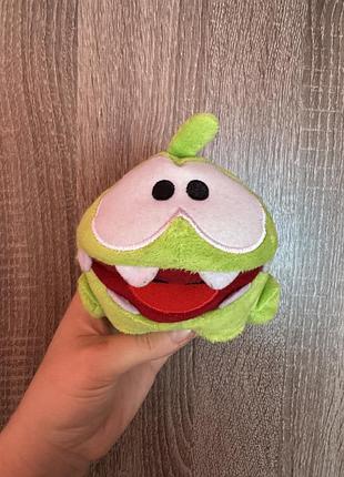 М'яка іграшка — персонаж ом ням з гри cut the rope, виготовлена компанією weber toys із салатового велюру та плюшу