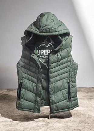 Женская стеганая жилетка superdry fuji gilet зеленого цвета с фирменным принтом на подкладке и капюшоном раз.м
