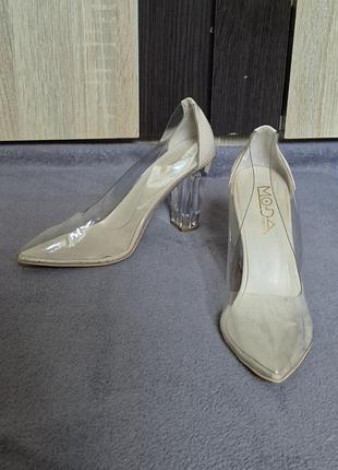 Бежевые туфли-лодочки от бренда moda имеют прозрачные вставки и необычный каблук