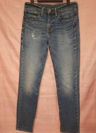 Мужские джинсы levi's 511 slim fit из вываренного голубого денима с характерными легкими потертостями и светлым пятном на правом бедре.