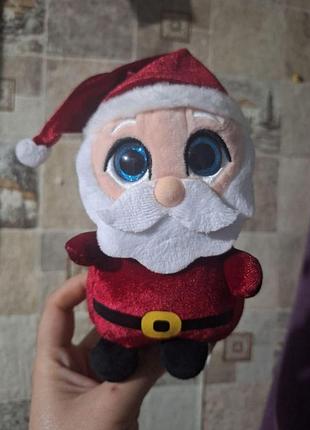 Плюшева іграшка санта клауса від кeel toys має великі блискучі сині очі та червоний костю...
