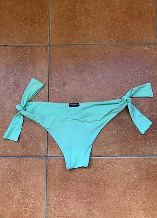 Плавки від бренду calzedonia мають яскравий м'ятно-зелений колір і регульовані зав'язки по боках.