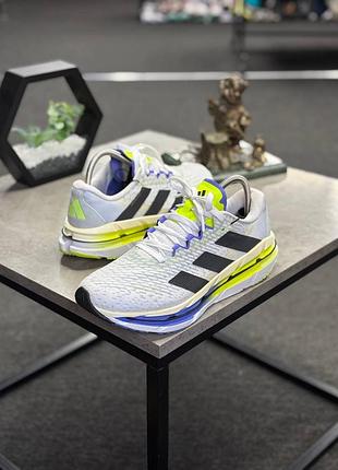 Кросівки adidas adistar byd running performance ji1226, що вирізняються білим сітчастим верхом із чорними смужками та яскраво-жовтими акцентами.