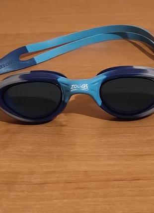 Детские очки для плавания zoggs super seal junior с синими линзами и мягким силиконовым уплотнителем, рассчитанные на возраст от 6 до 14 лет.