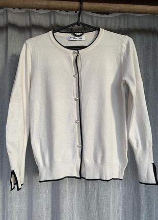 Жіночий кардиган від бренду zara виконаний у білому кольорі з контрастним чорним оздобленням та перламутровими ґудзиками
