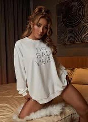 Білий лонгслів оверсайз прикрашений великим написом "no bad vibes" на грудях