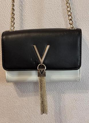 Стильна маленька сумочка valentino bags з колекції divina виконана в чорно-білій колірній гамі з характерним золотим логотипом v на застібці