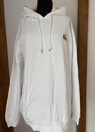 Біле худі lacoste з великим бежевим вишитим крокодилом на грудях.