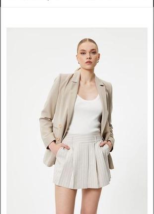 І бежеві шорти-спідниця від бренду zara мають елегантний дизайн у тонку вертикальну смужку з плісованими деталями