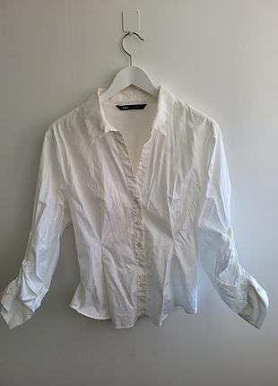 Белая рубашка zara имеет приталенный крой и классический воротник.