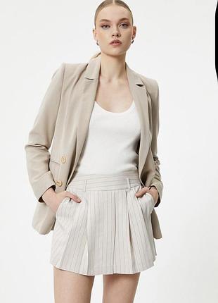 І бежеві шорти-спідниця від бренду zara мають елегантний дизайн у тонку вертикальну смужку з плісованими деталями