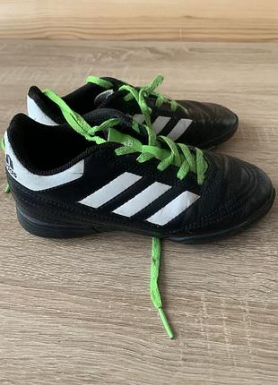 Дитячі футбольні бутси adidas goletto v tf, виконані в чорному кольорі з білими смугами та яскраво-зеленими шнурками.