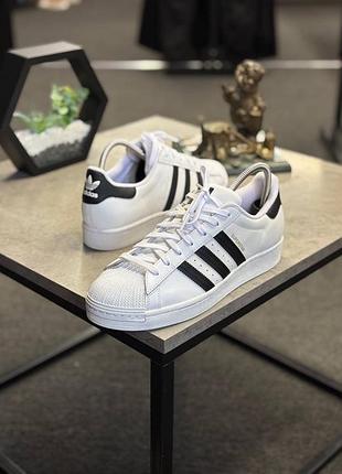 Класичні кросівки adidas superstar (модель fv3284 / eg4958) у білому кольорі з чорними фірмовими смужками та контрастним чорним задником.