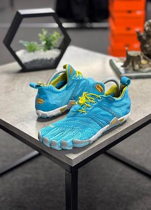 Кросівки — яскраво-блакитні мінімалістичні снікерси vibram fivefingers kmd evo з жовтими шнурками.